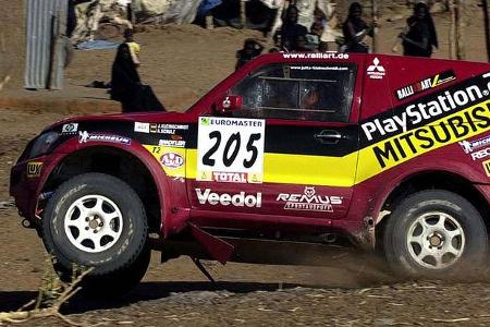 Kleinschmidt fährt auf drei Rädern an den Dorfbewohnern vorbei.