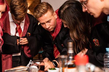 Leidenschaftliche Harry-Potter-Fans perfektionieren ihre Party mit ikonischen Gryffindor-Umhängen.