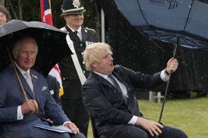 Prinz Charles (li.) kann sich ein Lächeln über Boris Johnsons Schirm-Problem nicht verkneifen.