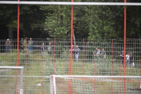 Die Trainingseinheit ist nicht öffentlich, dennoch versuchen einige Fans durch den Zaun einen Blick auf die Stars zu werfen.