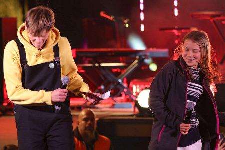 Greta Thunberg feiert auf der Bühne.