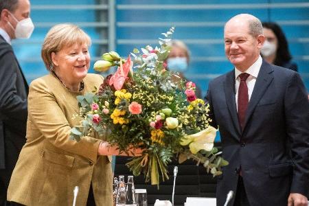 Angela Merkel freut sich über die Abschiedsblumen von Olaf Scholz.