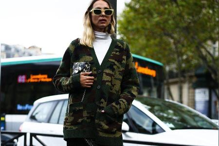Mode-Influencerin Candela Pelizza kombiniert ihren Camouflage-Cardigan mit Lederbleistiftrock und weißem Rollkragenpullover.