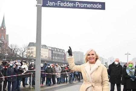 Witwe Marion Fedder unter dem neuen Straßenschild der Jan-Fedder-Promenade.