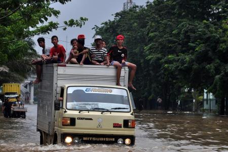 Überschwemmungen sind immer eine große Belastung für die Bevölkerung. Diese Kinder in Indonesien machen mit ihrer Fahrt auf ...