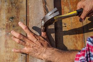 Mit dem Hammer auf den Daumen gehauen