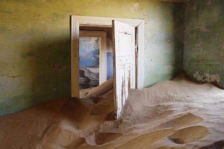 In einem verlassenen Haus steht Sand meterhoch in den Räumen