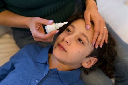 Junge bekommt Augentropfen