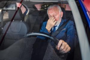 Sleepy businessman driving car