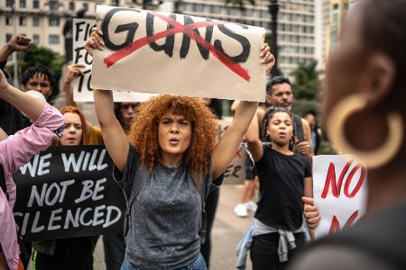 Frauen protestieren mit Plakaten gegen Waffen
