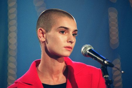 Potrait von Sinéad O'Connor vor einem Mikrofon.