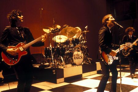 Mehrere Musiker mit Instrumenten auf einer Bühne am SIngen.