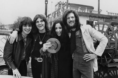 Drei Männer und eine Frau posieren vor der Kamera in schwarzweiß