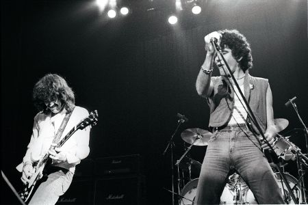 Musiker mit Gitarre und Sänger auf der Bühne in schwarzweiß