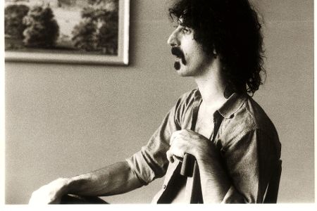 Mann mit langen Haaren spielt auf einem Instrument in schwarzweiß