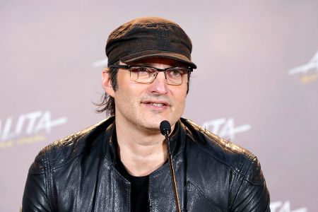 Mann mit Kappe und Brille vor Mikrofon