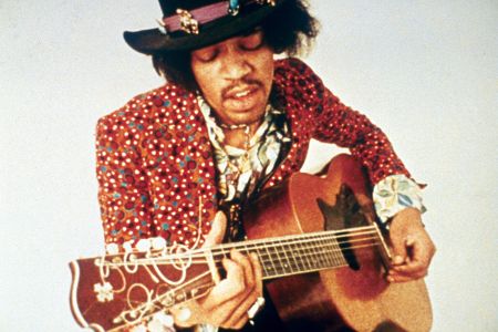 Mann mit Hut und Gitarre spielt und singt