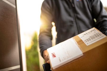 paketbote hält paket in der hand