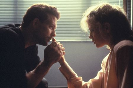 Mann hält Hand einer Frau und schaut ihr dabei in die Augen