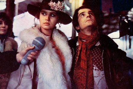 Frau mit Pelz und Hut und ihr männlicher Begleiter werden auf der Straße interviewt