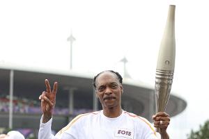 Kleines Tänzchen inklusive: Snoop Dogg trägt die olympische Fackel