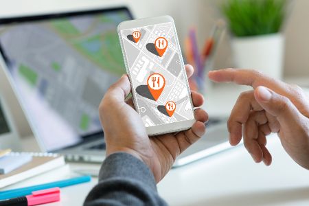 Handy mit Stadtplan, auf dem Restaurants auf einer Karte eingezeichnet sind
