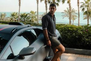 Mann präsentiert Modekollektion von Lamborghini und Orlebar Brown.