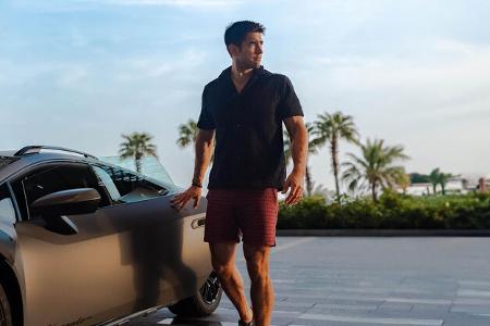 Mann präsentiert Modekollektion von Lamborghini und Orlebar Brown.