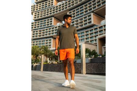 Mann präsentiert Modekollektion von Lamborghini und Orlebar Brown.