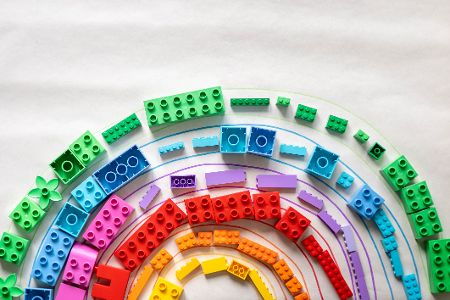 Bunte Legosteine zu einem Regenbogen gelegt