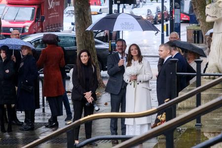 ...Fotos auf den Treppen, plus Entfernung des Konfettis bevor das nächste Paar herauskam. Das alles natürlich, wie es sich für London gehört, im Regen.