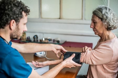 Bei einer Dame wird der Blutdruck gemessen