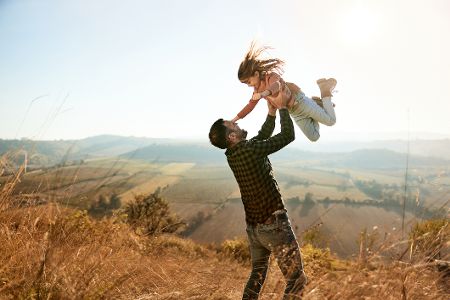 Mann hebt sein Kind in die Luft