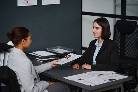 Frau, die ihre Dokumente zur Beantragung eines Visums aushändigt