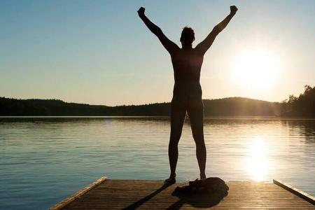 A man stretches his arms on a jetty