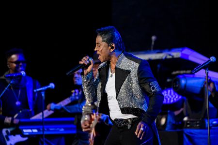 Jermaine Jackson mit Mikrofon in der Hand auf einer Bühne