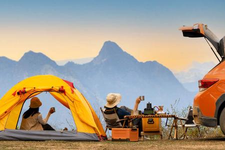 Campingszene mit orangener Zeltmontur und Carcamper