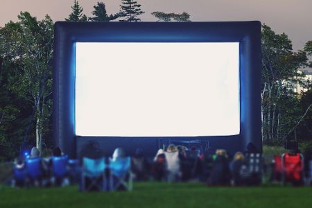 Freiluftleinwand mit Zuschauern auf einer Wiese