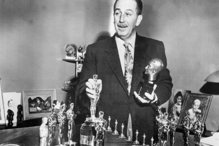 Walt Disney mit einigen seiner Oscars