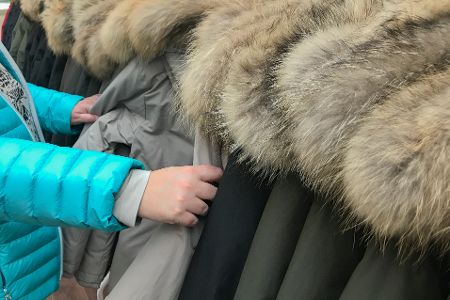 Jacken mit Pelzkragen hängen auf einer Stange