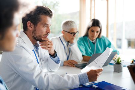 Gruppe von Arzten sitzt zusammen und diskutiert Ergebnisse