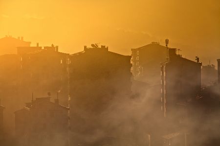 Smog über einer Stadt im Morgenlicht