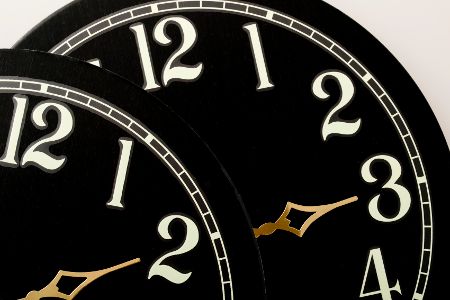 Zwei Uhren mit unterschiedlichen Uhrzeiten zur Zeitumstellung