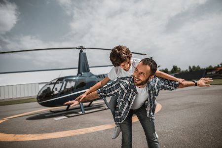 Vater und kleiner Sohn vor einem Helikopter