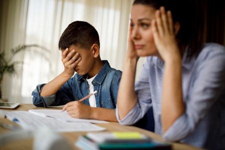 Mutter und Sohn sitzen vor den Hausaufgaben und sind überfordert