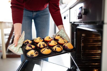 Mutter holt Kekse aus dem Backofen