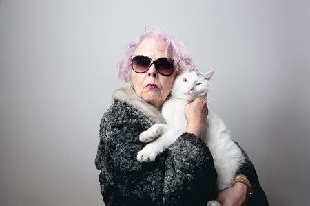 Exzentrische Dame mit Katze auf dem Arm