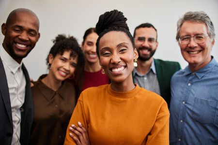 Gruppe von diversen Menschen lächelt in die Kamera