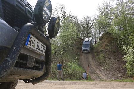Offroad-Fahrtraining: Bergabfahren durch den Wald in einer Kurve