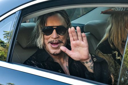 Mickey Rourke winkt vom Rücksitz aus Auto